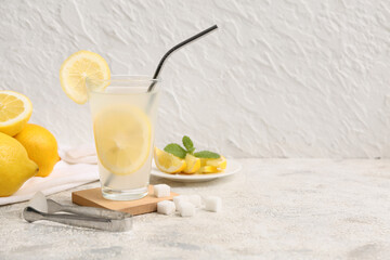 Glass of fresh lemonade with sugar on white background