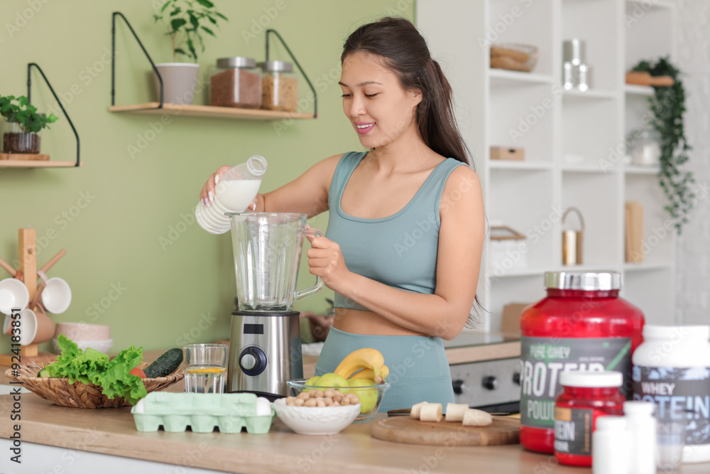 Canvas Prints sporty young happy asian woman pouring milk into blender for protein shake at home