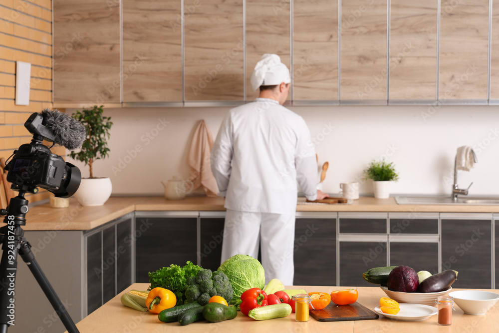 Sticker Male chef with fresh vegetables recording cooking video in kitchen