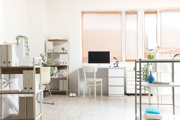 Interior of medical office with doctor's workplace and shelf units