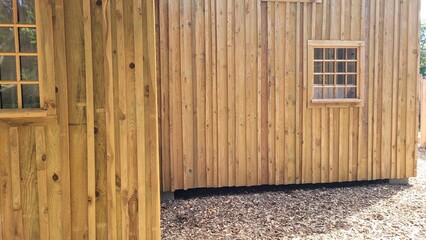 Façade d'une maison en bois clair, avec fenêtres 