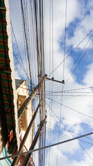 tangled cables, electric poles filled with tangled cables with a clear sky background. Electric cables or internet lines in Tulungagung City.