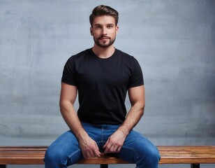 Fototapeta premium Portrait of a Man Sitting Against a Blue-Grey Wall