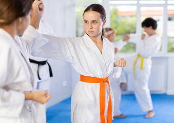 Child boys and girls partners during martial arts karate class train to perform basic blows to opponent with hands and feet. Preparation of athletes for competitions