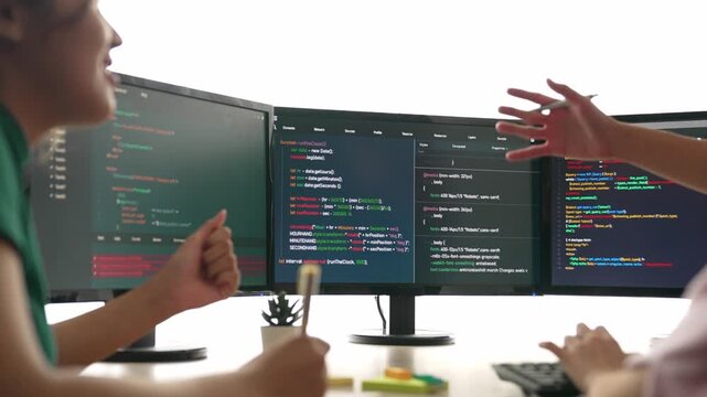 Slow motion back end software developer engineer for computer programming working together on debugging writing computing code, solving complex algorithms display on monitor in office. Burgeoning
