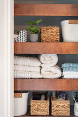 Neatly organized bathroom closet with floating shelves