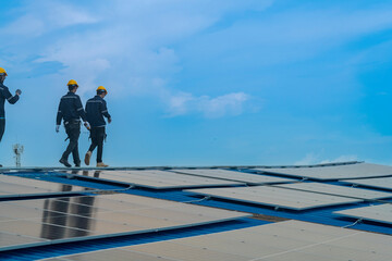 Worker Technicians are working to construct solar panels system on roof. Installing solar photovoltaic panel system. Men technicians walking on roof structure to check photovoltaic solar modules.
