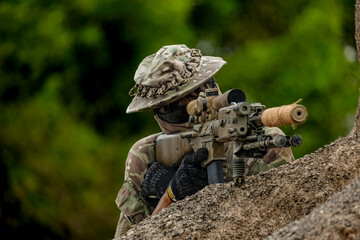 A group of military men in combat gear patrol in the middle of a desert and tropical jungle....