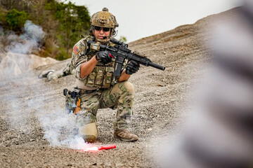 A group of military men in combat gear patrol in the middle of a desert and tropical jungle....