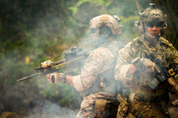 A group of military men in combat gear patrol in the middle of a desert and tropical jungle....
