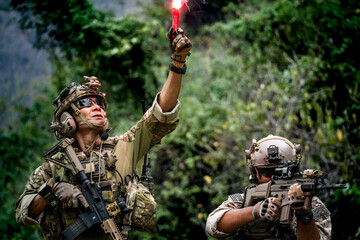A group of military men in combat gear patrol in the middle of a desert and tropical jungle....