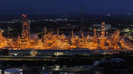 Fototapeta premium High angle view of industrial plant with pipes and tanks for mixing chemicals and gases at night.