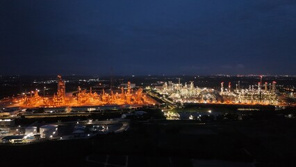 High angle view of industrial plant with pipes and tanks for mixing chemicals and gases at night.