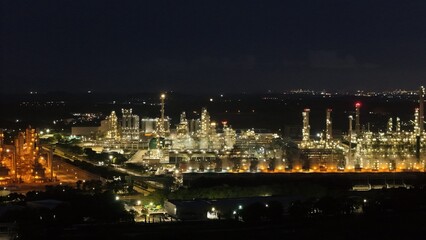 High angle view of industrial plant with pipes and tanks for mixing chemicals and gases at night.