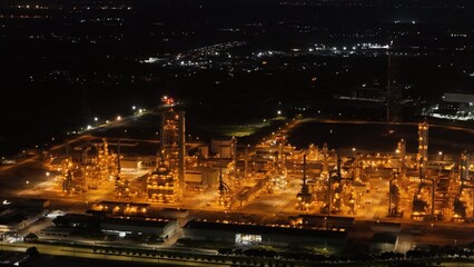High angle view of industrial plant with pipes and tanks for mixing chemicals and gases at night.