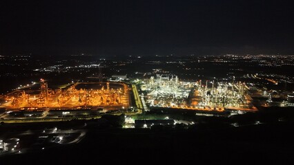 Fototapeta premium High angle view of industrial plant with pipes and tanks for mixing chemicals and gases at night.
