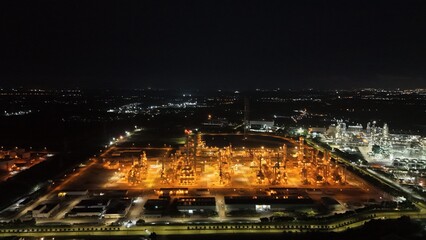 High angle view of industrial plant with pipes and tanks for mixing chemicals and gases at night.