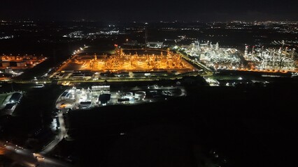 High angle view of industrial plant with pipes and tanks for mixing chemicals and gases at night.