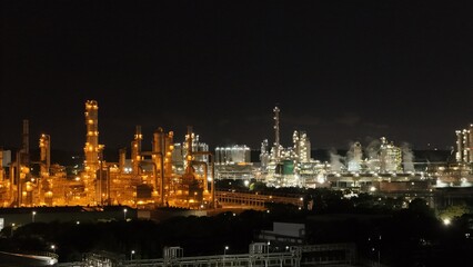 Fototapeta premium High angle view of industrial plant with pipes and tanks for mixing chemicals and gases at night.