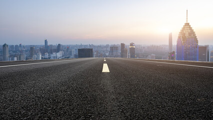 Expansive Urban Road Leading to a Vibrant City Skyline at Sunset