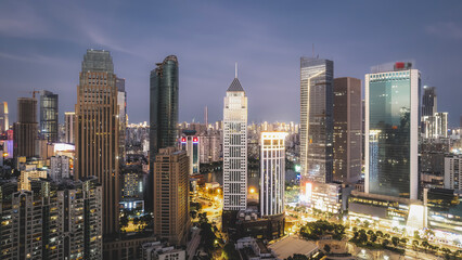 Obraz premium Stunning Night View of a Modern City Skyline Illuminated by Urban Lights