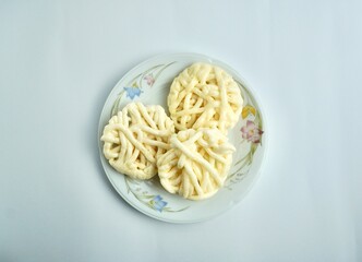 Three kerupuk putih warung crackers on white porcelain plate from above top angle view. Food object photography isolated on white background.