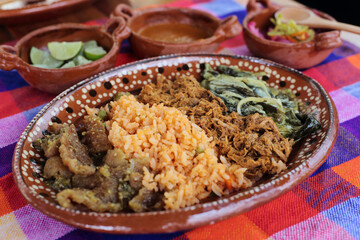 Plate of Traditional mexican food with chicharron, rice, cochinita and rajas