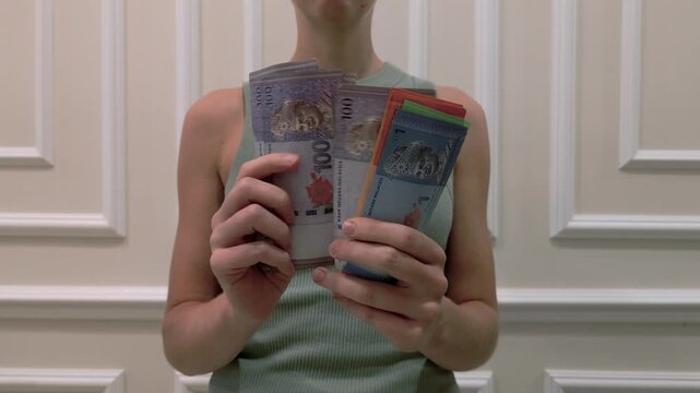 Woman counting the Malaysian ringgit - the currency of Malaysia, close-up