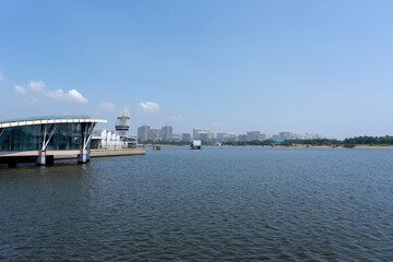 Obraz premium Serene Waterfront Cityscape with Modern Architecture and Clear Blue Skies