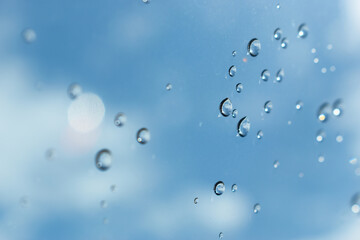 water drop on mirror with blue sky and white cloud background