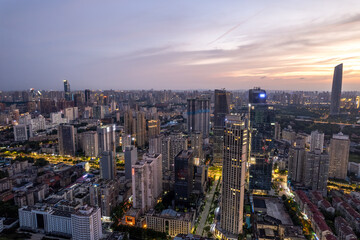 Obraz premium Stunning Urban Cityscape at Sunset with Twinkling Lights
