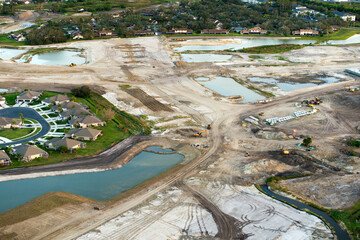 Construction site with building equipment on prepared ground in American suburbs. Aerial view of...
