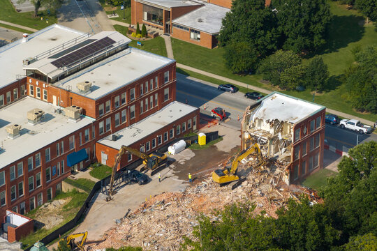 Demolition of Historic Edwards Building in Berea, Kentucky. Crawler excavator demolishing brick walls of old structure