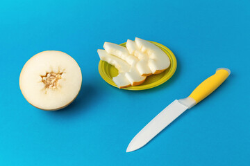 Freshly Sliced Melon with Knife on Blue Background