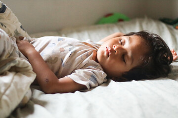 Adorable cute toddler or baby boy sleeping on bed at morning with sweet dream in bedroom Lovely child get deep sleep and get relax and happy during lying down on bed Little infant boy get good sleep