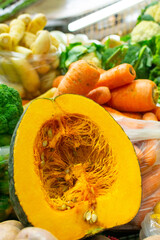 Ahuyama (Cucurbita moschata) cut in half along with carrots, broccoli and arracachas at a farmer's market in Medellín, Colombia.