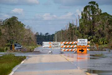 Road closed for roadworks and danger of flooding with warning signs blocking driving of cars