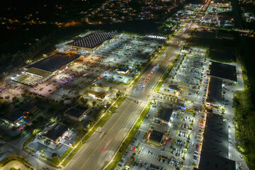 Shopping plaza stores and malls at sunset and American wide highway with many driving cars in North...