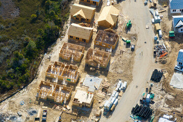 Wooden houses under construction in new developing suburban area. Development of residential...