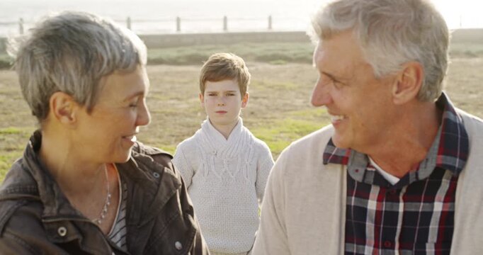 Park, senior couple and angry grandson with a tantrum outdoor during summer for travel or forehead. Face, smile or third wheel young boy jealous or sad with his grandmother and grandfather or family