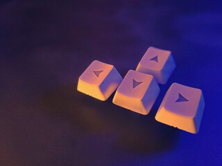 Keyboard keys on a black background in neon light. Competitive video games.