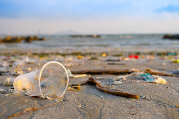 Trash, plastic cups and plastic bags at the beach. environmental problem concept and healing the world	