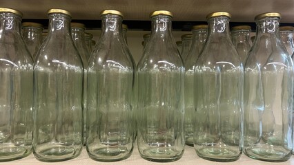 Transparent glass bottles in a row.Production of glass bottles for beverages.display of bottles in a shop