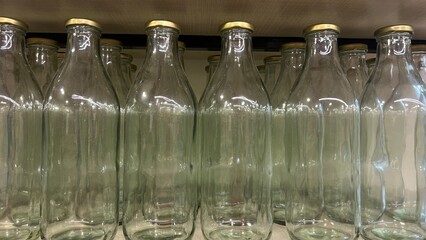 Transparent glass bottles in a row.Production of glass bottles for beverages.display of bottles in...
