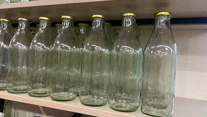 Transparent glass bottles in a row.Production of glass bottles for beverages.display of bottles in...
