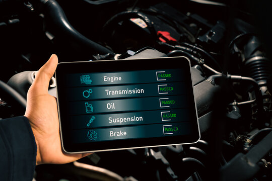 Car repair and maintenance concept , Mechanic checks car maintenance with wireless scan tool with car engine compartment background.