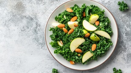 Top view of a detox salad with kale, almonds, and sliced apples, arranged on a white ceramic plate.