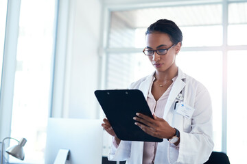 Woman, doctor and reading with clipboard for medical results, information or research at hospital. Female person or healthcare employee checking paperwork, documents or health forms for procedure