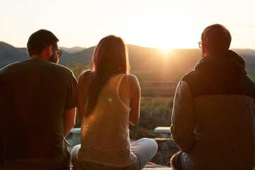 People, relax and bonding in outdoor at sunset, peace and view of nature for freedom on holiday. Friends, back and weekend trip for calm retreat on vacation, travel and together at dusk for love
