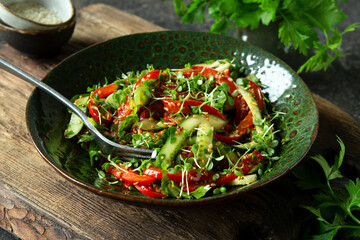bowl with salad with cucumbers and bell peppers on the table
